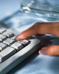 Woman Pressing Enter Key on Computer Keyboard